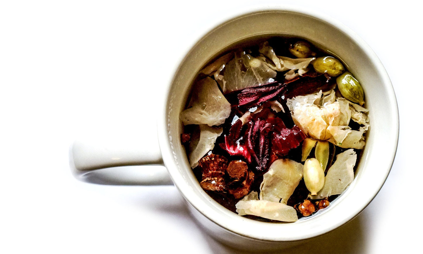 Liquorice root, hibiscus, cinnamon, rose petals, cardamom, clove in a cup.